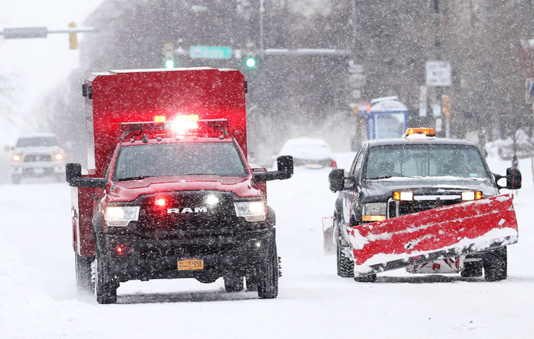 An emergency vehicle speeds past other drivers on Delaware Avenue in Buffalo on Monday.