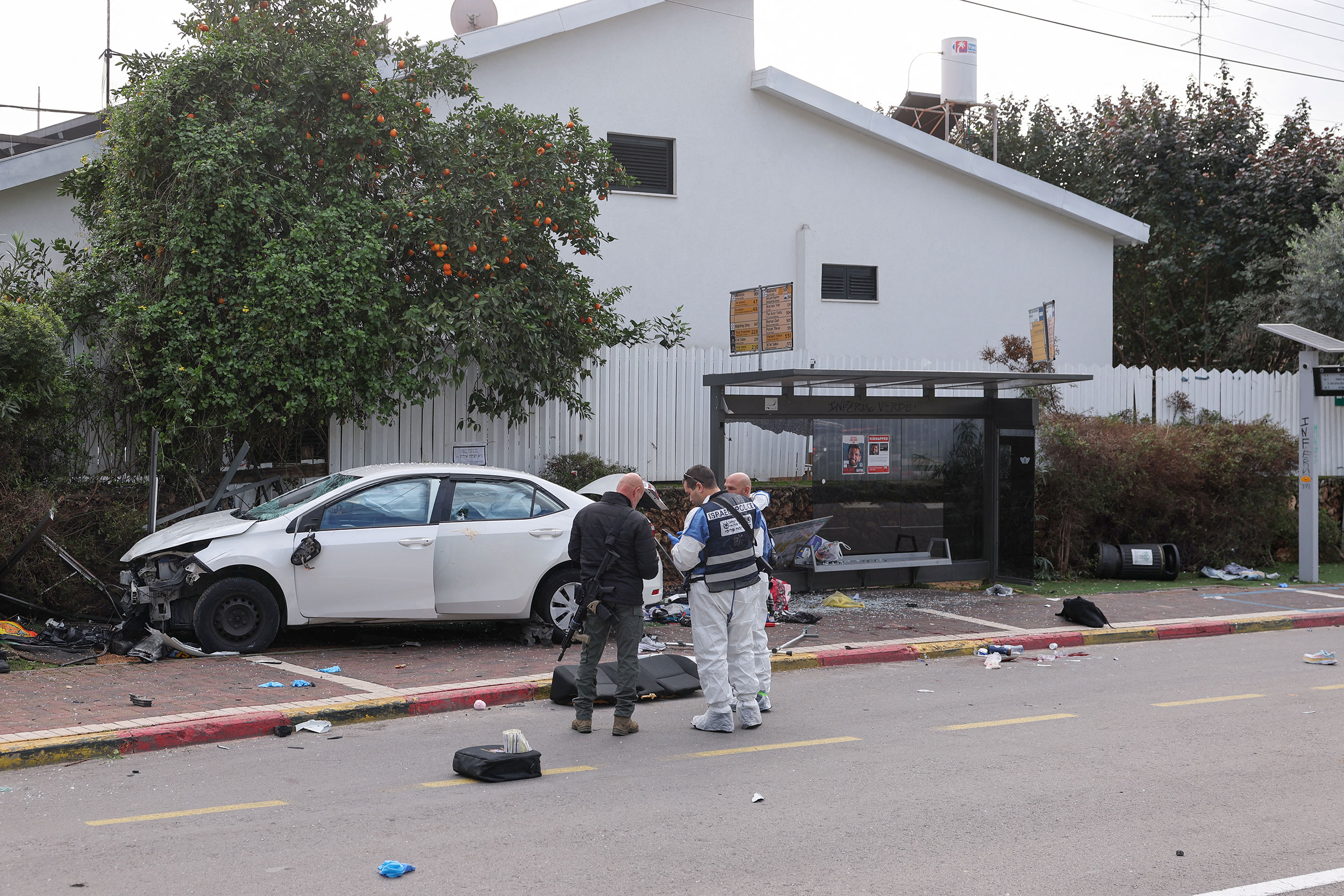 Israel police forensics personnel inspect a damaged car following the attack in Raanana on January 15.