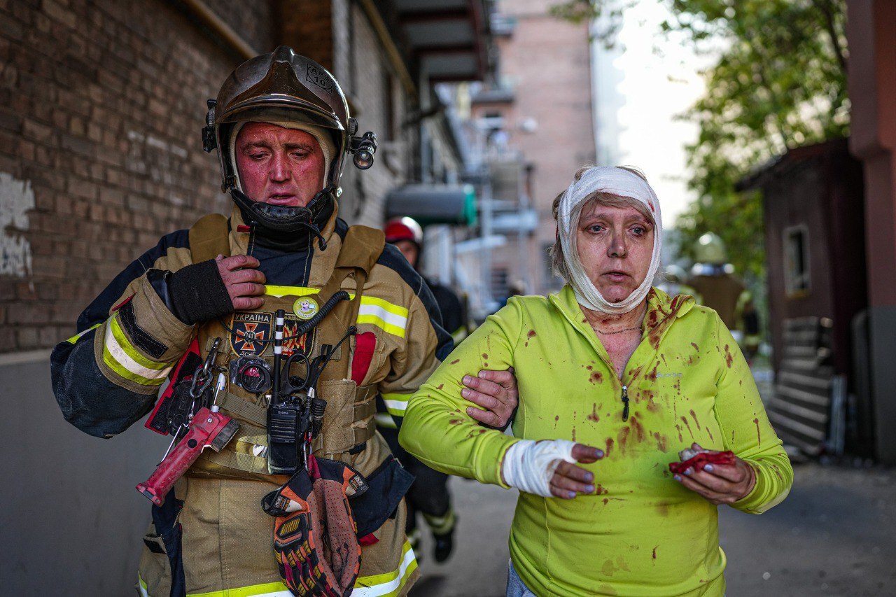 A fireman helps an injured civilian after several explosions rocked the Shevchenkivskyi district of the Ukrainian capital, Kyiv, on October 10.