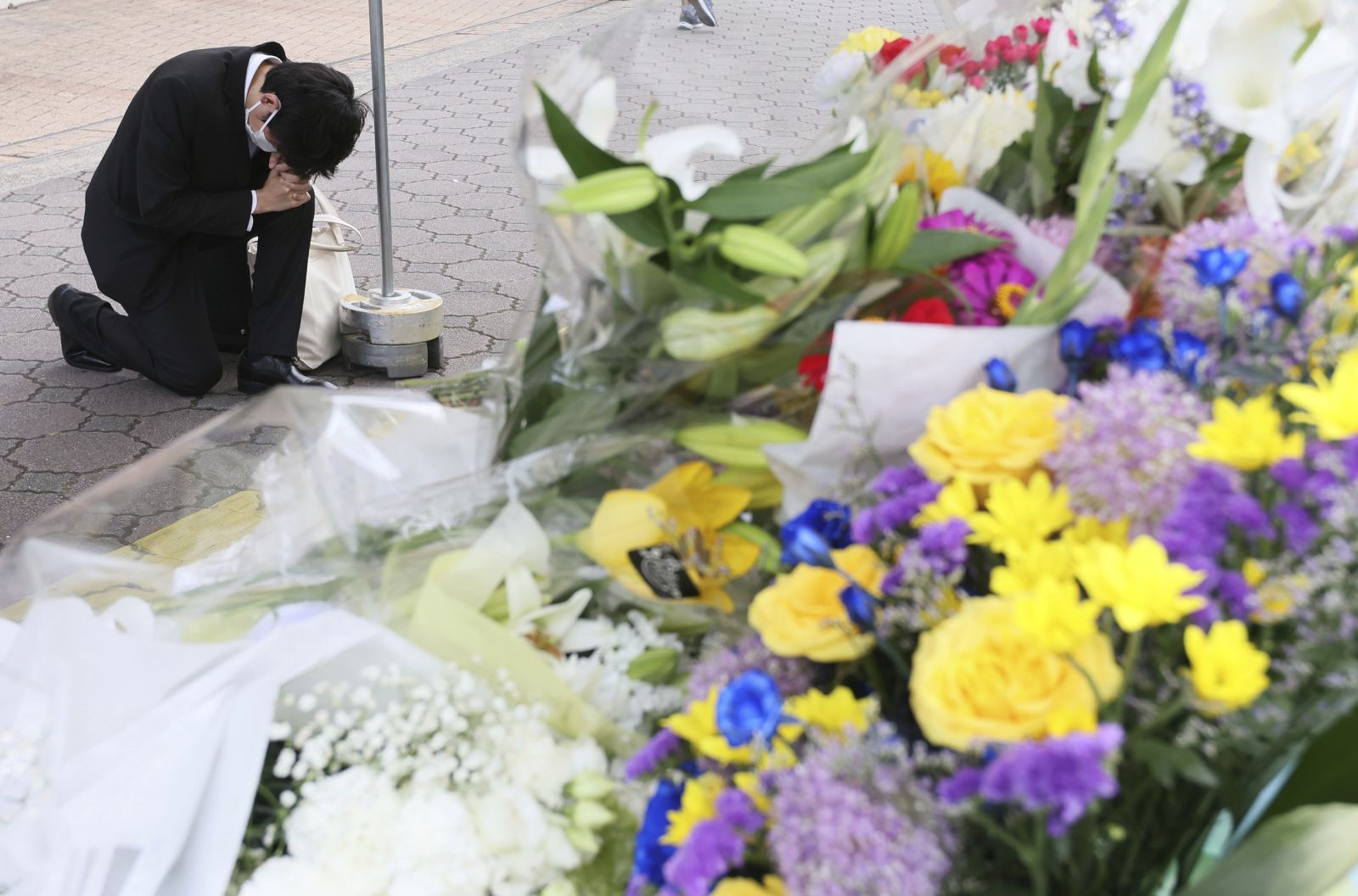People offer flowers and prayers near a site where former prime minister Shinzo Abe was shot.