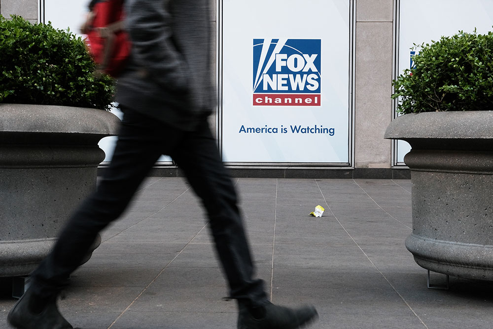 People walk by the News Corporation headquarters, home to Fox News, on April 18, in New York City.