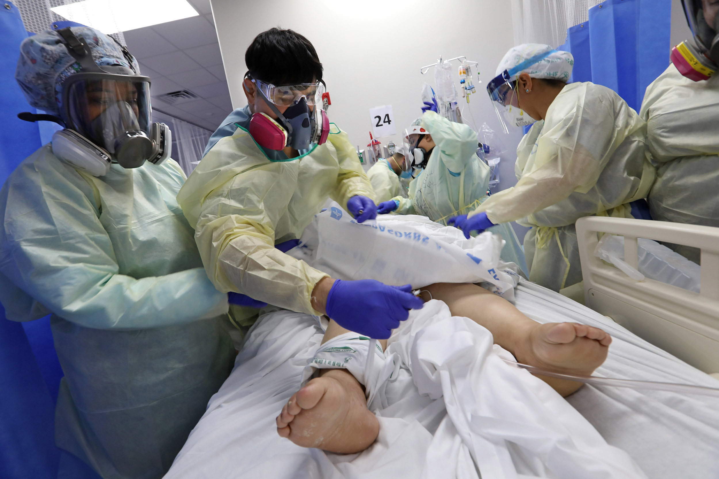 Visiting nurse Gabriel Leyva, 34, (second from left) of Downey, CA, treats a coronavirus patients at Doctors Hospital at Renaissance on July 17, in Edinburg, Texas. 