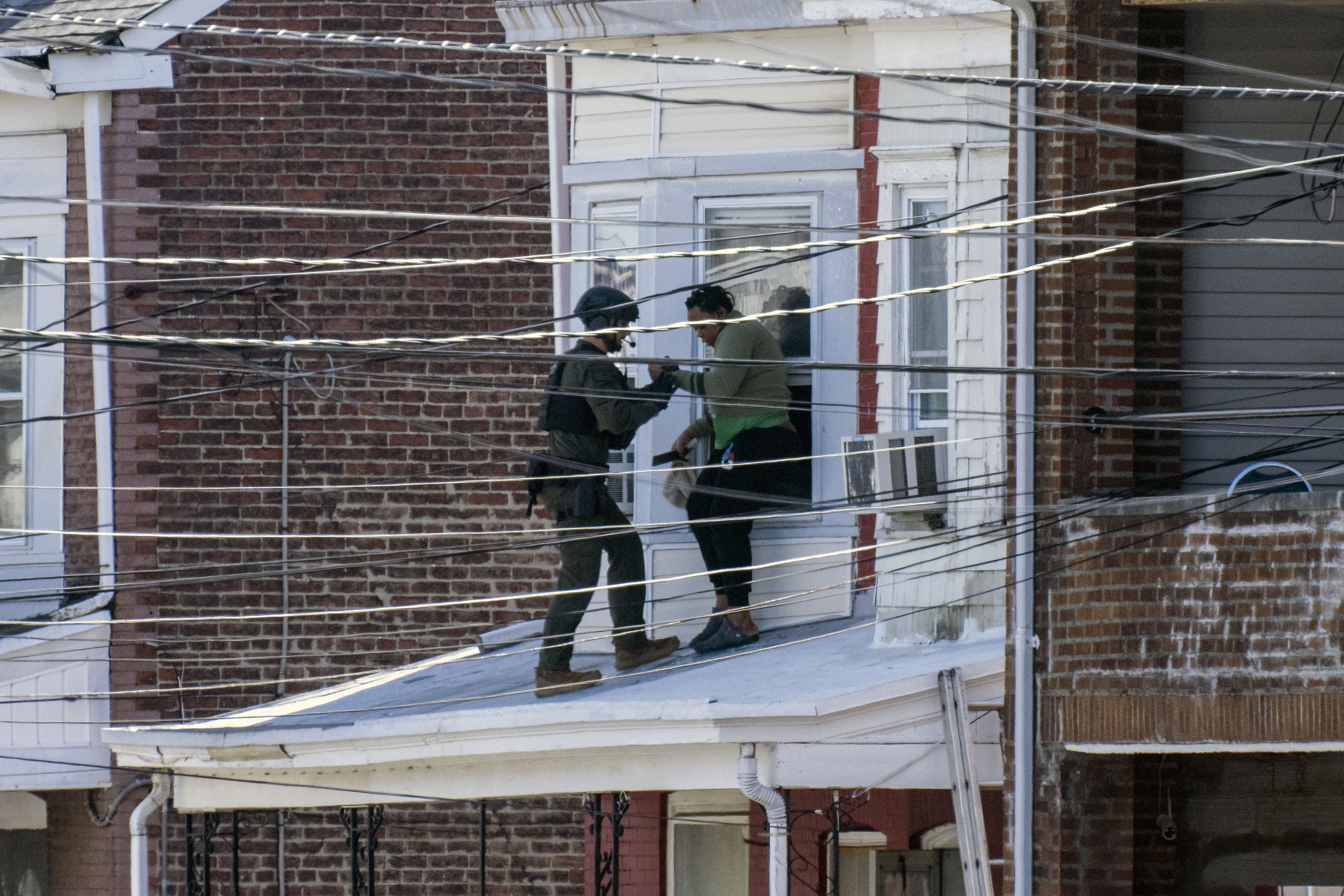 Police remove people from a home in Trenton New Jersey, on March 16, after reports of a gunman, who is suspected of a shooting spree in Pennsylvania, was barricaded in the house.