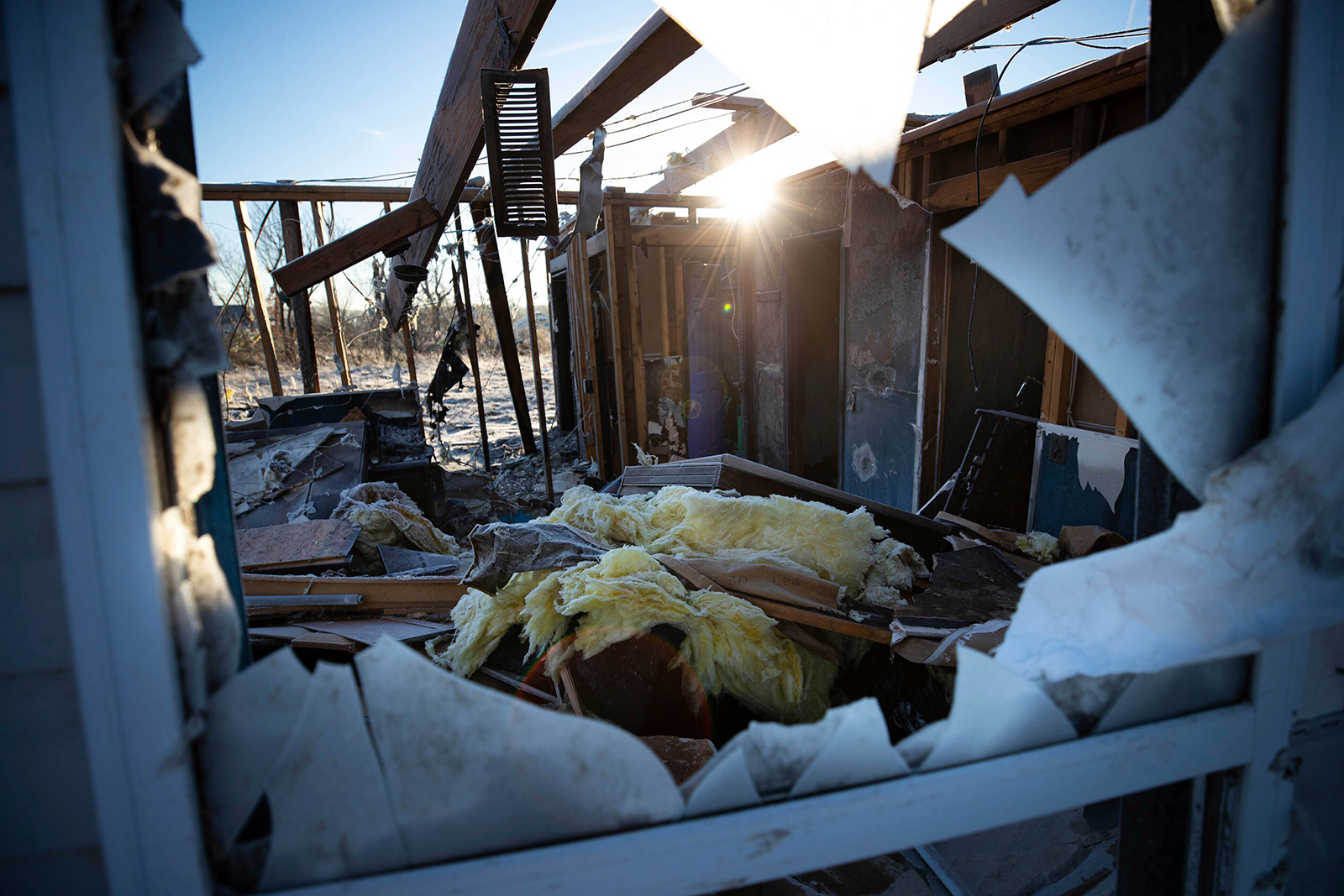 The remains of a house seen through a broken window after a tornado in Dawson Springs, Kentucky, on Sunday, December 12.(Michael Clubb/AP)