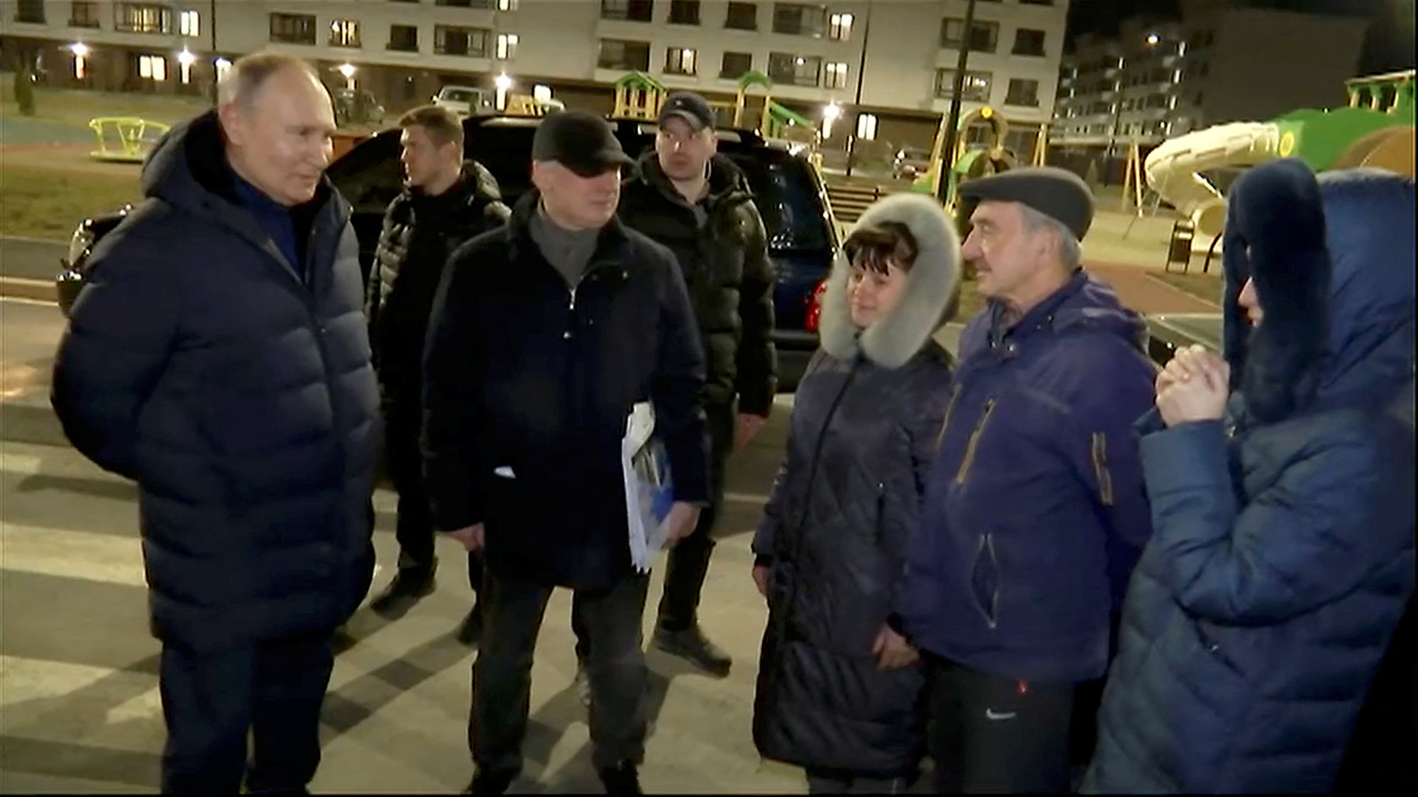 Russian President Vladimir Putin, left, listens to local residents as he visits Mariupol in Russian-controlled Ukraine, in this still image taken from handout video released on March 19.