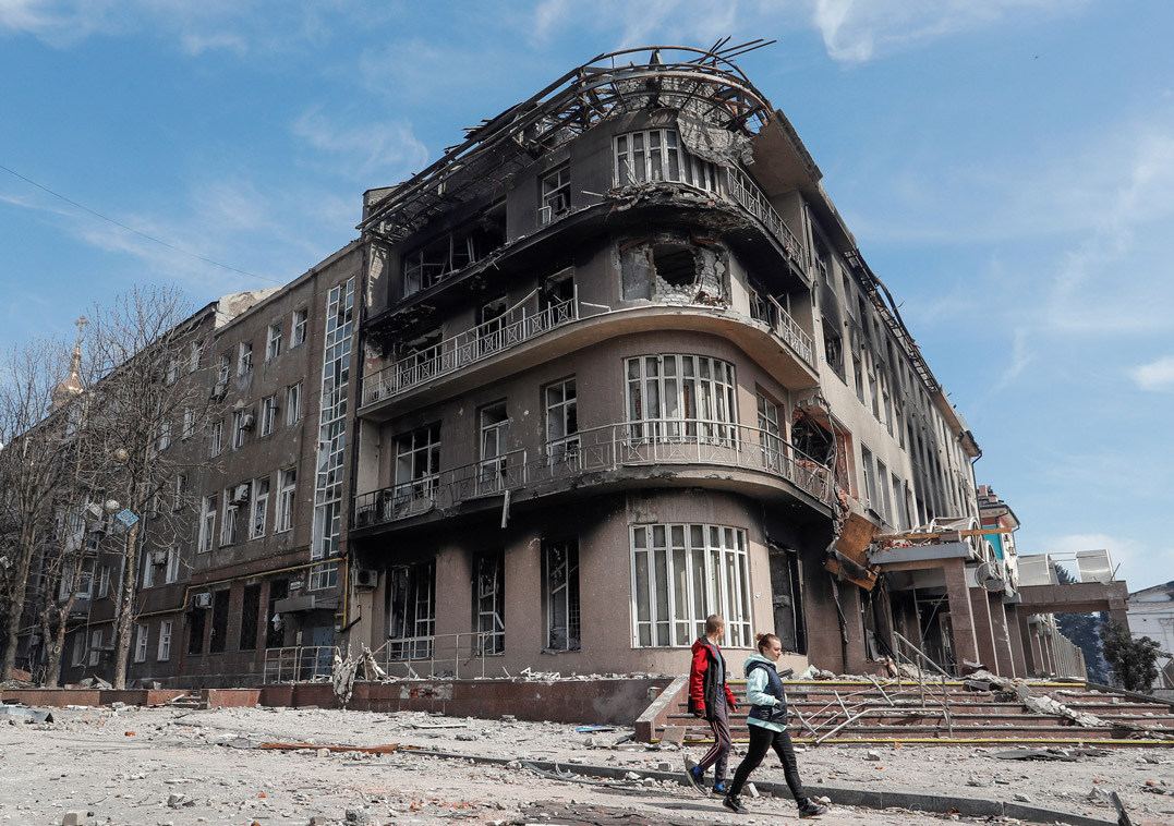 Residents walk near a destroyed building in Mariupol, on April 10.  