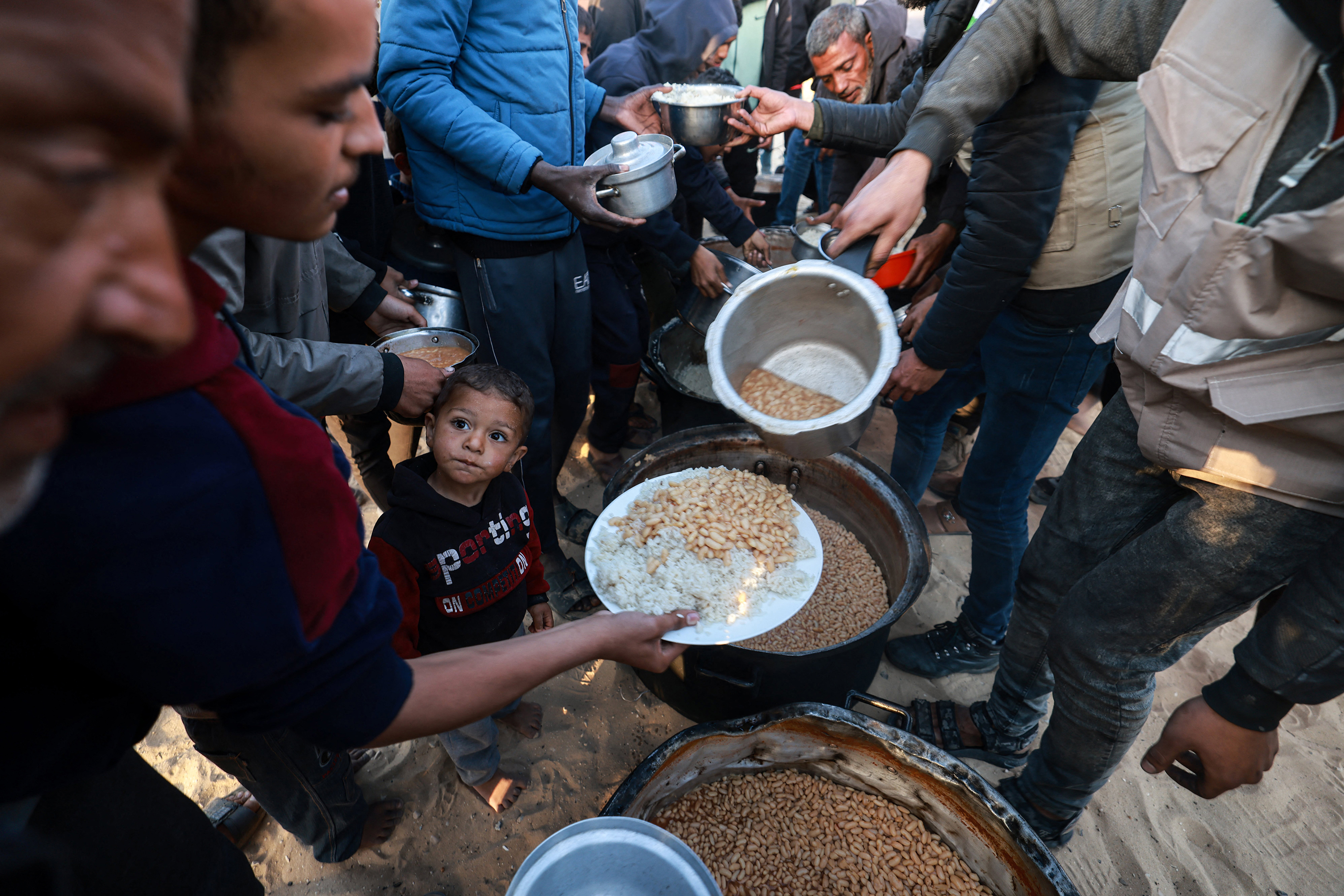 Displaced Palestinians collect food donated by a charity before an iftar meal in Rafah, Gaza, on March 11.