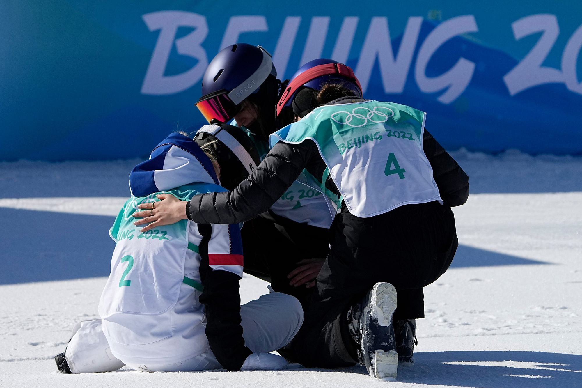 Silver medalist Tess Ledeux of France, left, is comforted by gold medalist Eileen Gu of China and bronze medalist Mathilde Gremaud of Switzerland during the freestyle skiing big air finals on Tuesday.