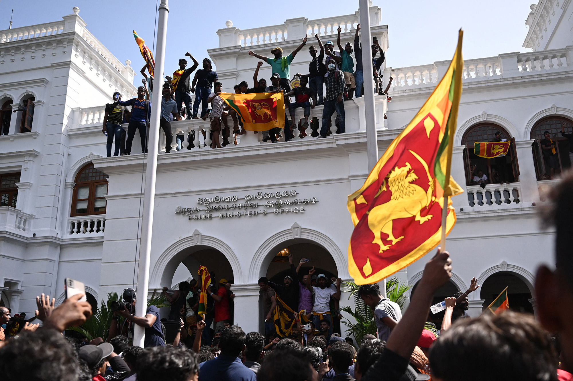Demonstrators shout slogans and wave Sri Lankan flags during an anti-government protest inside the office building of Sri Lanka's prime minister in Colombo on July 13.