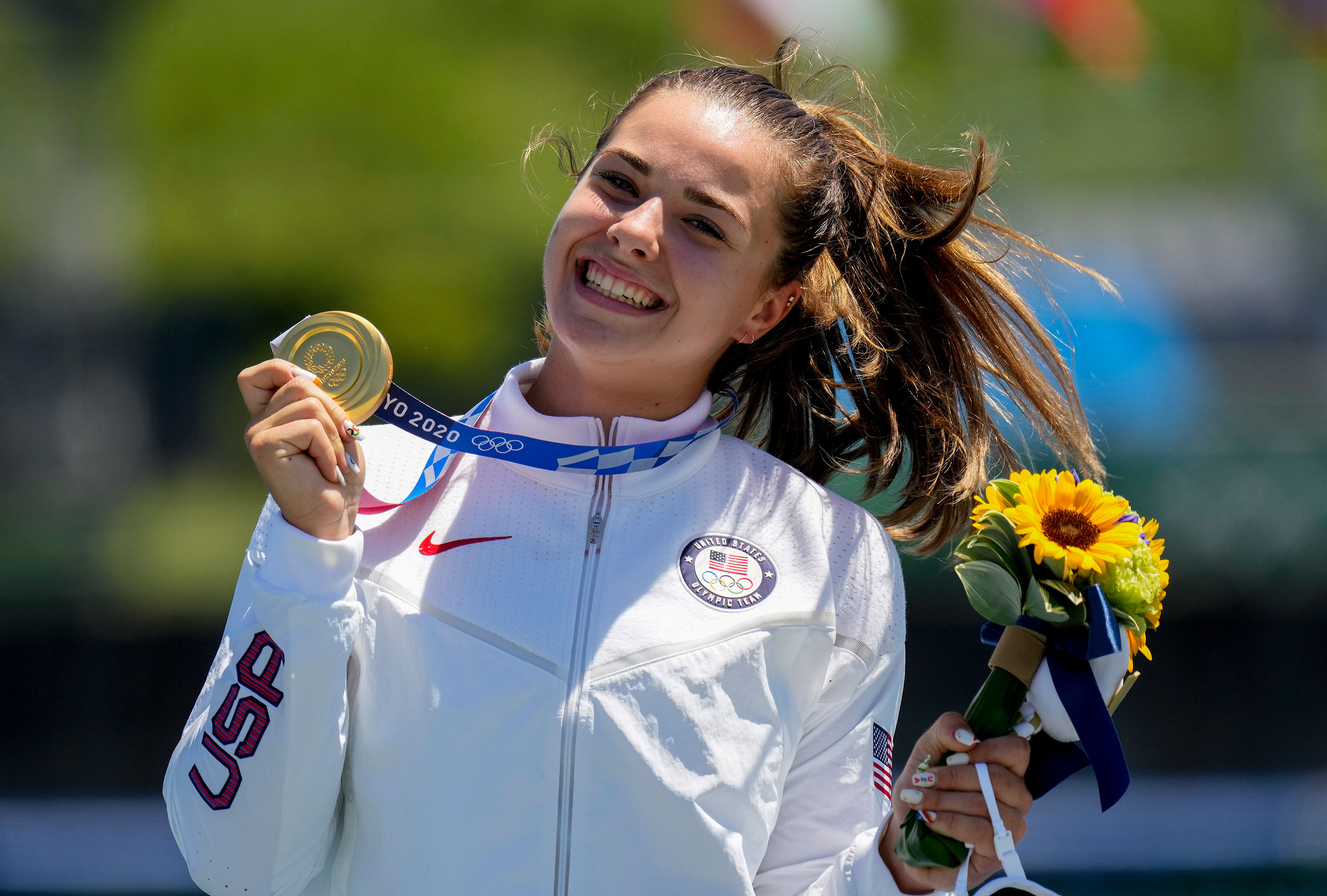 American Nevin Harrison holds her up gold medal after winning the canoe single 200 meter final on Thursday.