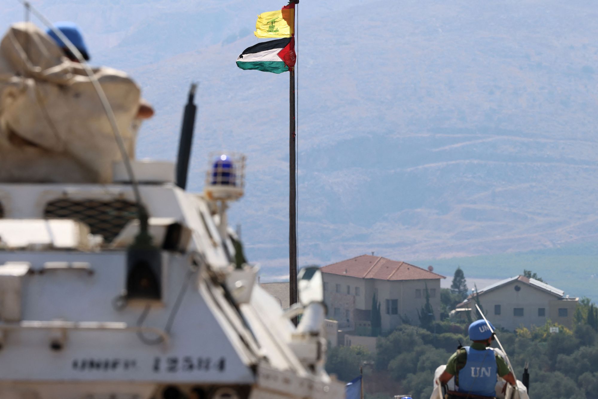 The Palestinian flag and the flag of Hezbollah are seen as UN peacekeepers patrol the border area between Lebanon and Israel on October 13.
