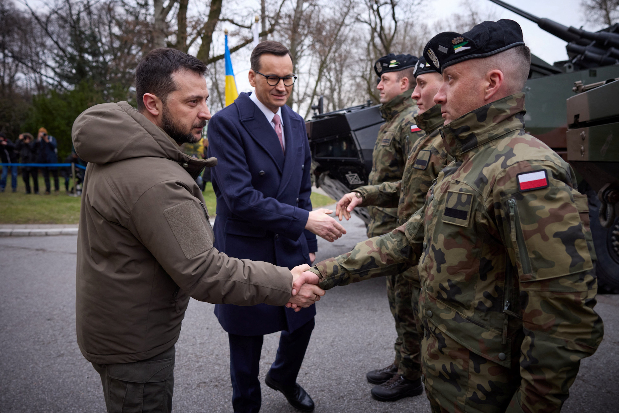 Zelensky and Polish Prime Minister Mateusz Morawiecki shake hands with Polish service members in Warsaw on Wednesday.