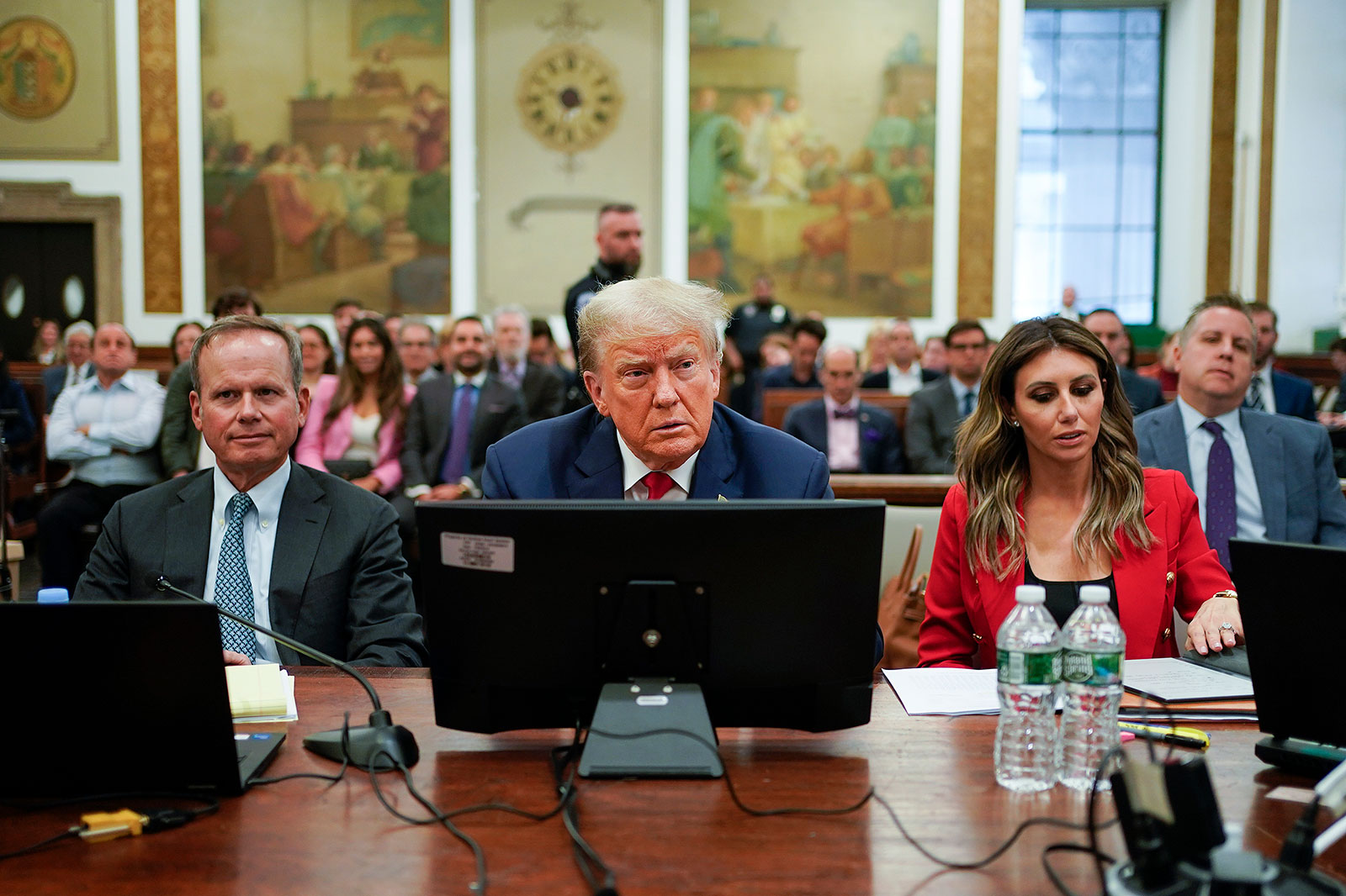Former President Donald Trump is flanked by members of his legal team on the second day of a civil fraud trial in New York on Tuesday, October 3.