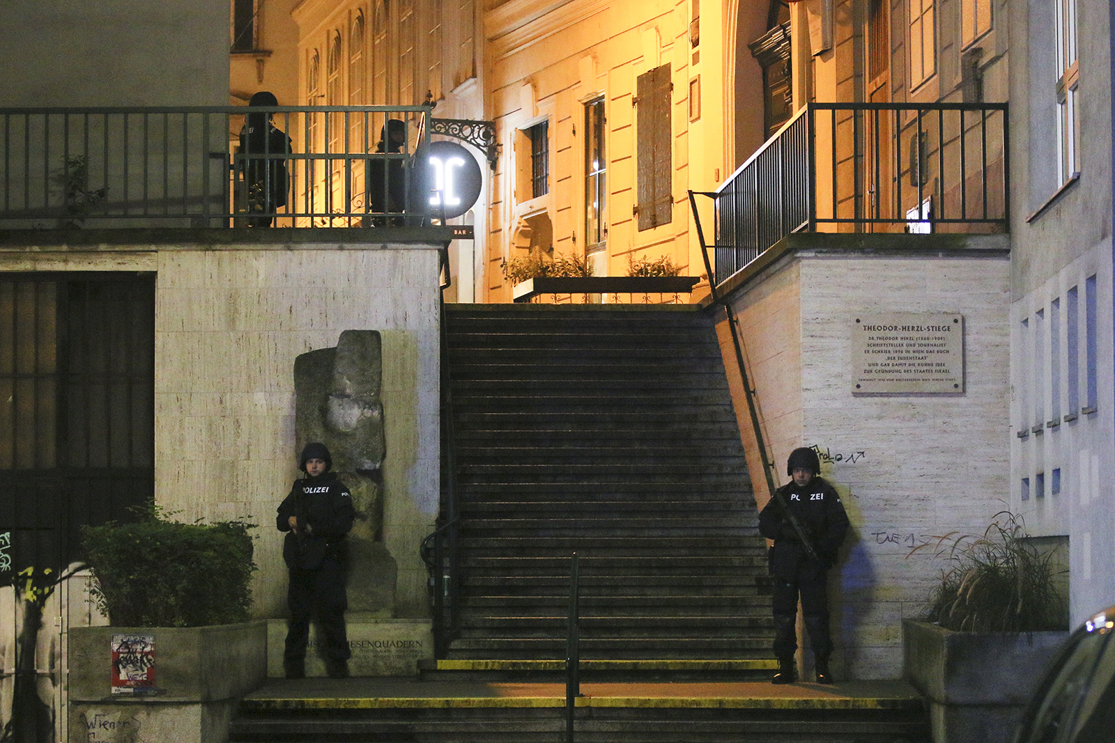 Police officers stay in position at stairs named 'Theodor Herzl Stiege' near a synagogue after Austrian police say several people have been injured and officers are out in force following gunfire in Vienna on Monday, November 2.