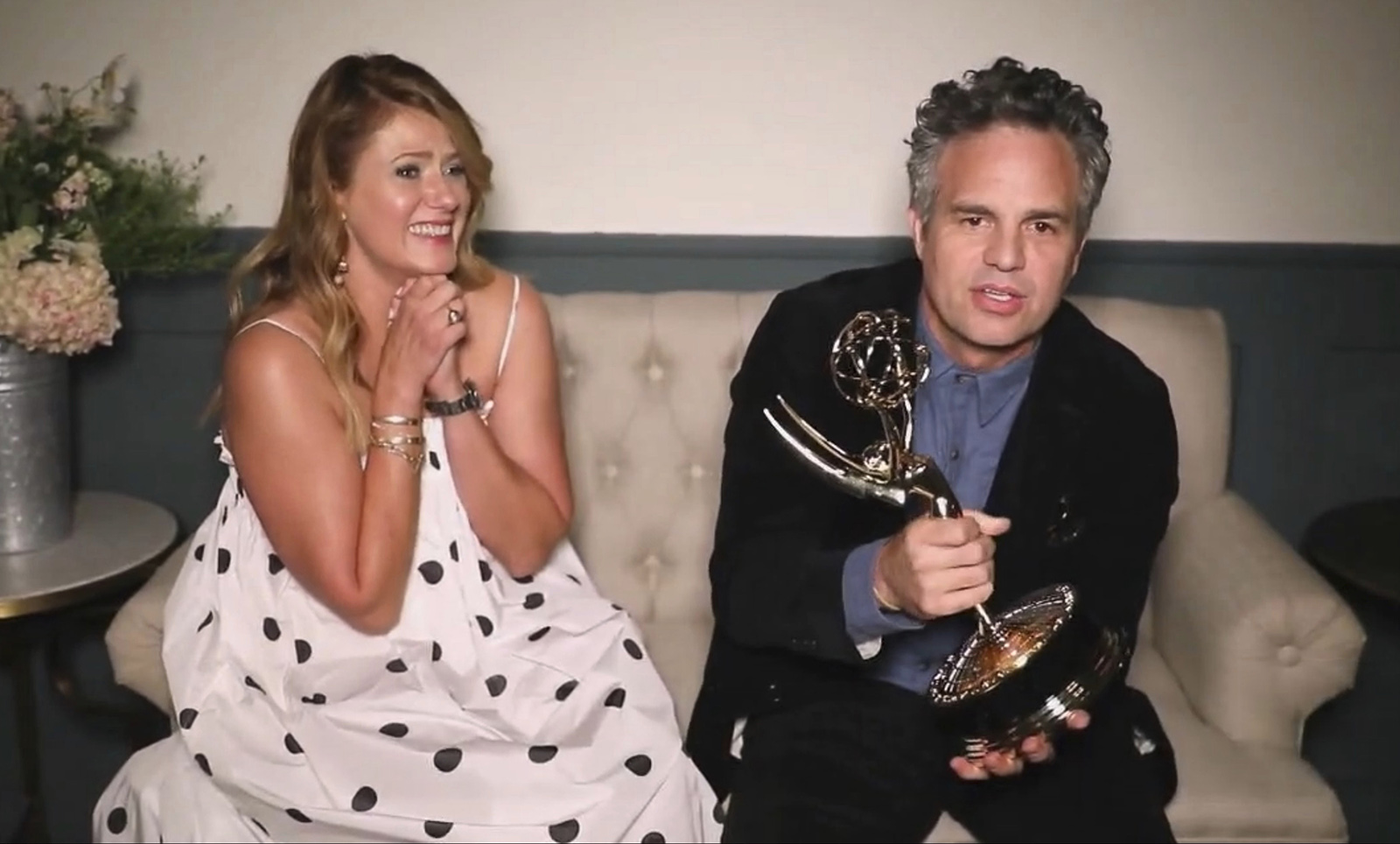 In this video grab captured on Sept. 20, 2020, courtesy of the Academy of Television Arts & Sciences and ABC Entertainment, Mark Ruffalo accepts the award for outstanding lead actor in a limited series or movie for "I Know this Much is True" during the 72nd Emmy Awards broadcast. Looking on at left is Ruffalo's wife Sunrise Coigney. 