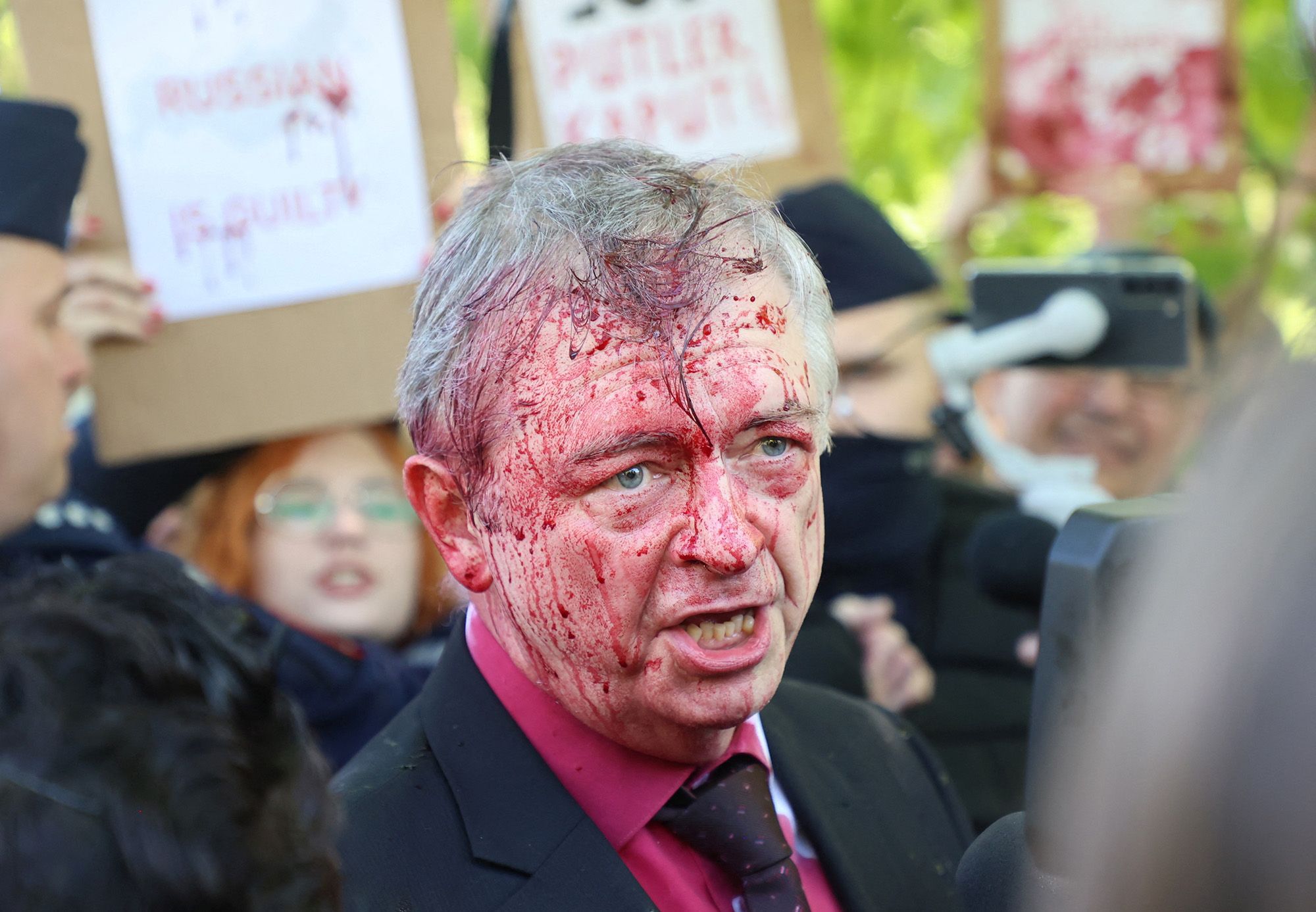 Russia's ambassador to Poland Sergey Andreev is covered in red substance thrown by protesters as he came to celebrate Victory day at the Soviet Military Cemetery in Warsaw, Poland, on May 9.