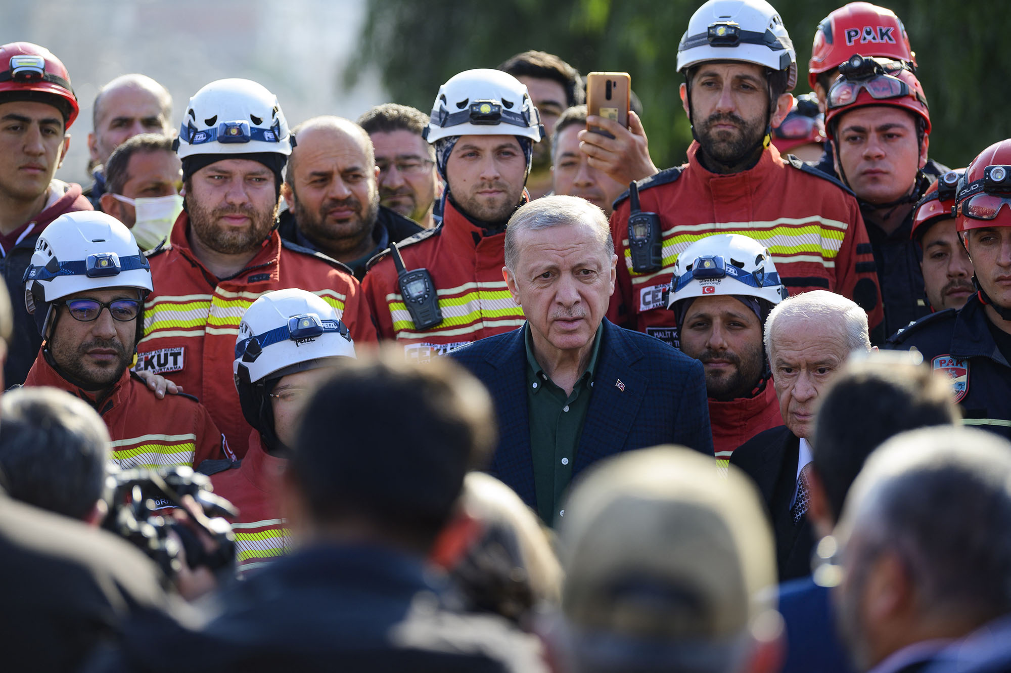 Turkish President Recep Tayyip Erdogan, centre, stands with rescue workers as he visits the hard-hit southeastern province of Hatay, Turkey, on February 20.