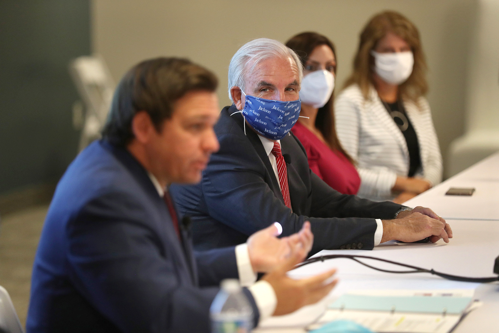 Mayor of Miami-Dade Carlos A. Gimenez (Right) listens as Florida Gov. Ron DeSantis (Left) speaks during a press conference in Miami on July 07.