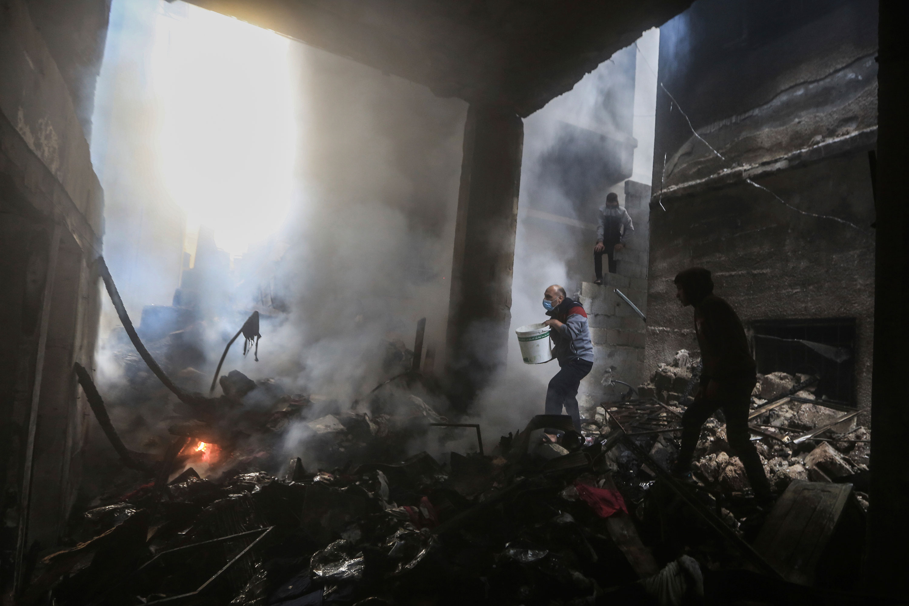 People attempt to put out a fire after an Israeli airstrike in Khan Younis, Gaza, on Wednesday. 