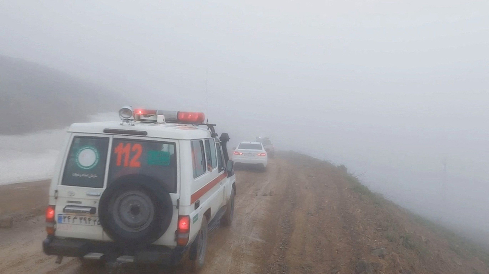 在这张来自视频的剧照中，5 月 19 日，在伊朗东阿塞拜疆省瓦尔扎坎，伊朗总统易卜拉欣·莱西乘坐的直升机坠毁后，一辆救护车和其他车辆在雾蒙蒙的道路上行驶。