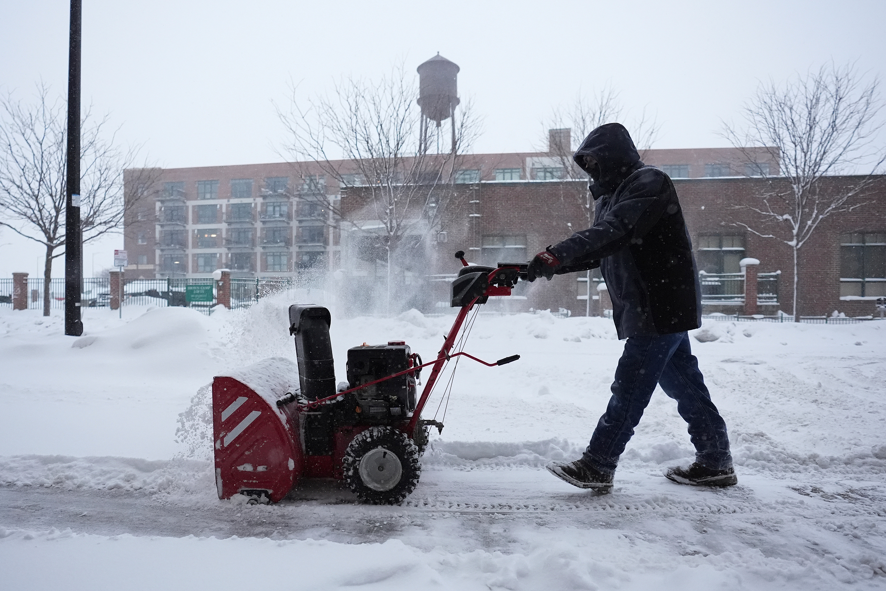 A man clears snow off a sidewalk in Des Moines, Iowa, on Friday, January 12. 