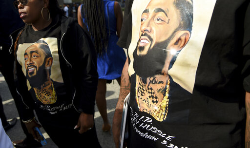 Guests wear T-shirts in tribute to Nipsey Hussle at the late rapper's memorial service on Thursday at the Staples Center in Los Angeles. 