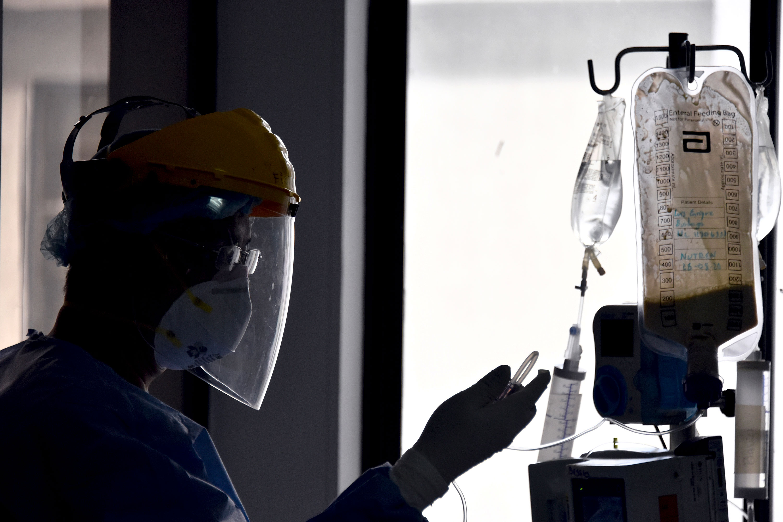 A health worker checks the IV line of a coronavirus patient in the Intensive Care Unit at de La Samaritana University Hospital on August 28 in Bogota, Colombia. 