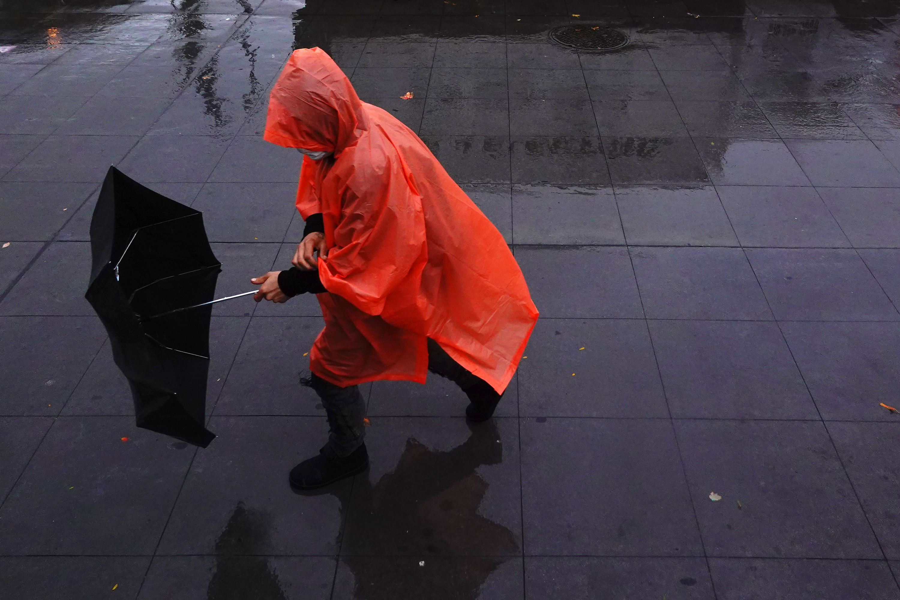 A person struggles with their umbrella during an autumn nor'easter in Brooklyn, New York, on October 26. 