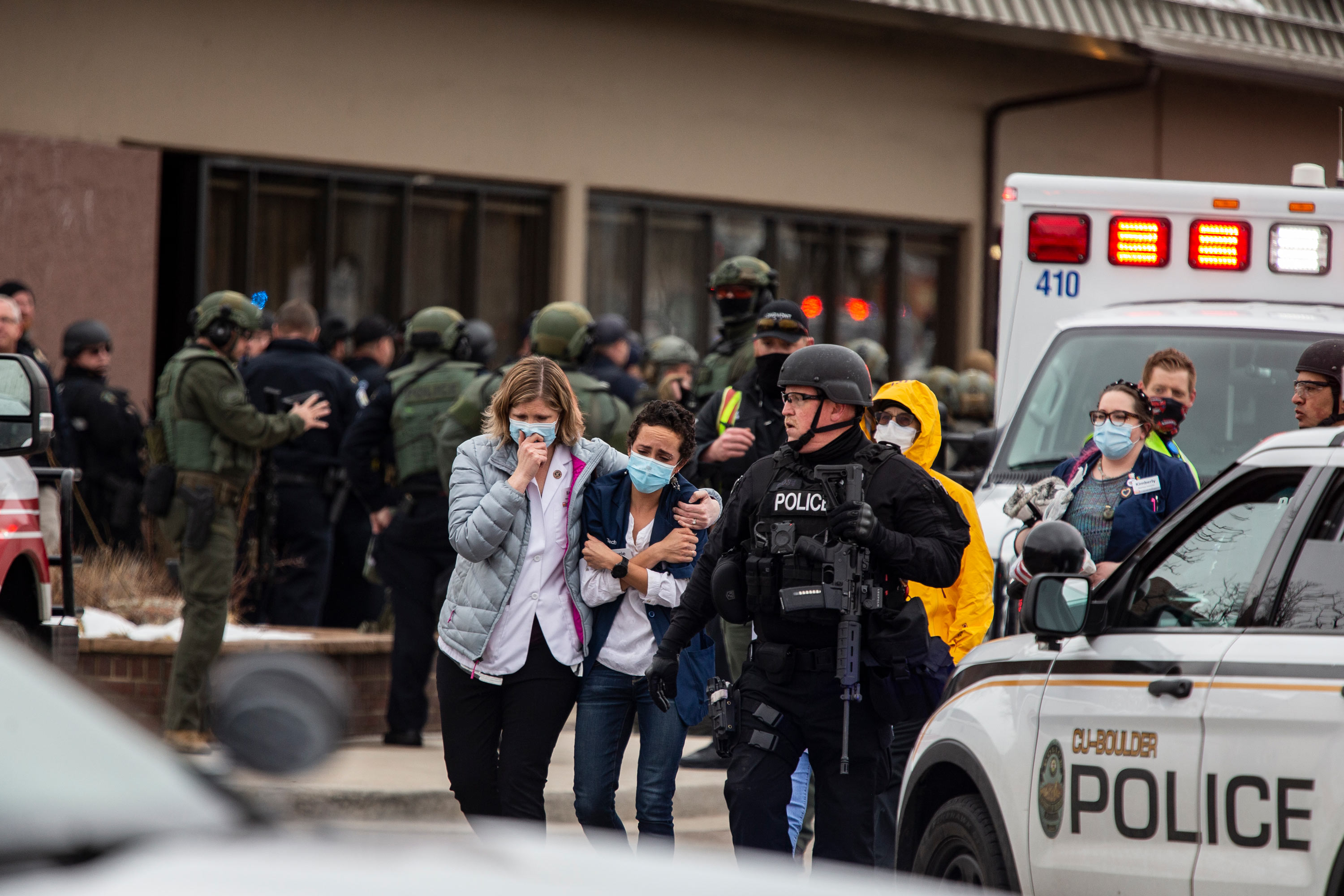 Healthcare workers walk out of a King Sooper's Grocery store after a gunman opened fire on March 22 in Boulder, Colorado. 