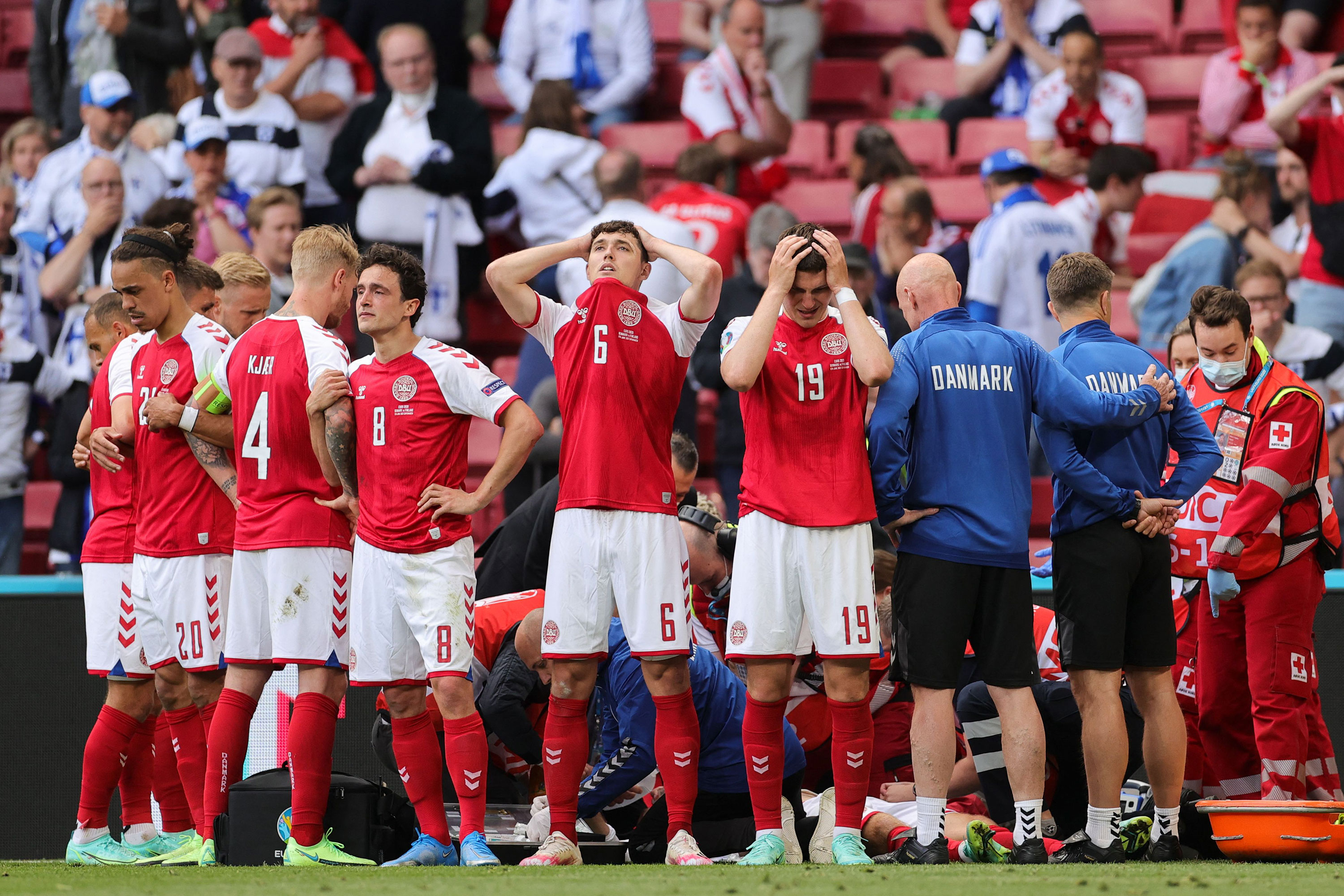 Denmark's players react as paramedics attend to midfielder Christian Eriksen after he collapsed on the pitch during the UEFA EURO 2020 Group B football match June 12, 2021, in Copenhagen. 
