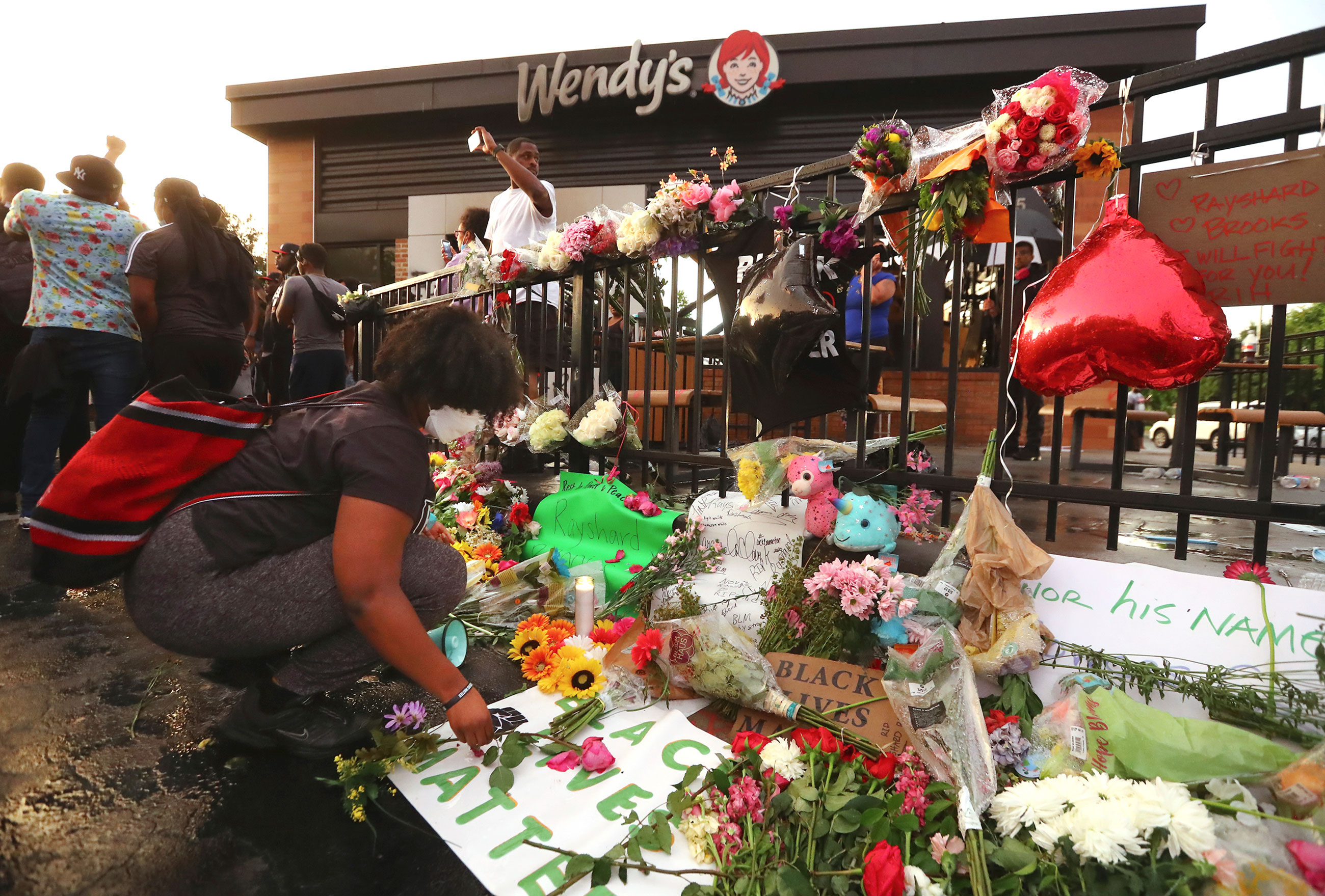 People build a memorial at a Wendy's in Atlanta on Sunday, where Rayshard Brooks was shot and killed during a confrontation with police on June 12.