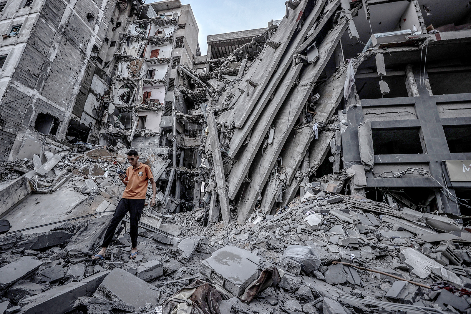 A person walks through the debris of a destroyed building in Gaza City, on Sunday, October 8. 