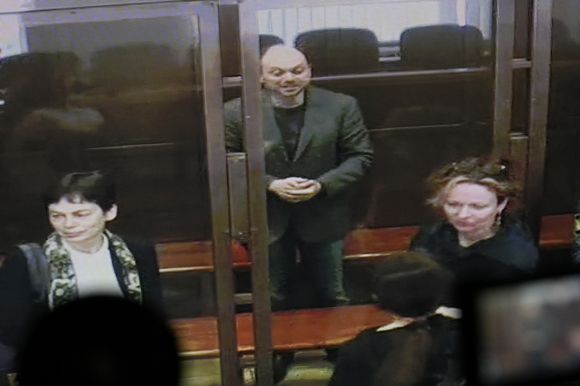 Vladimir Kara-Murza is seen on a TV screen as he stands in glass cage as he listens to the verdict in a courtroom at the Moscow City Court in Moscow, Russia, on April 17.