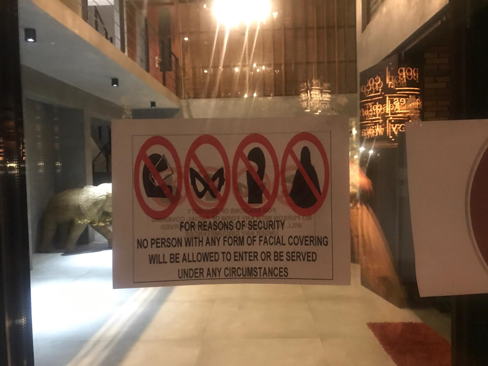Signs at the Ella Flower Garden Resort banning people with face coverings from entry.