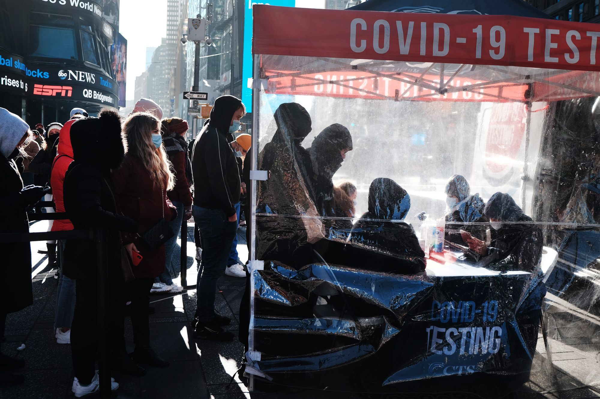People wait in line at Times Square to get tested for Covid-19 on December 20, in New York City. 