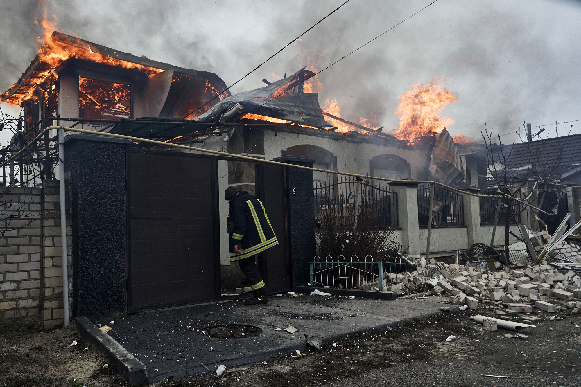 A firefighter stands at a burning house hit by the Russian shelling in Kherson, Ukraine, on the Orthodox Christmas Eve, January 6.