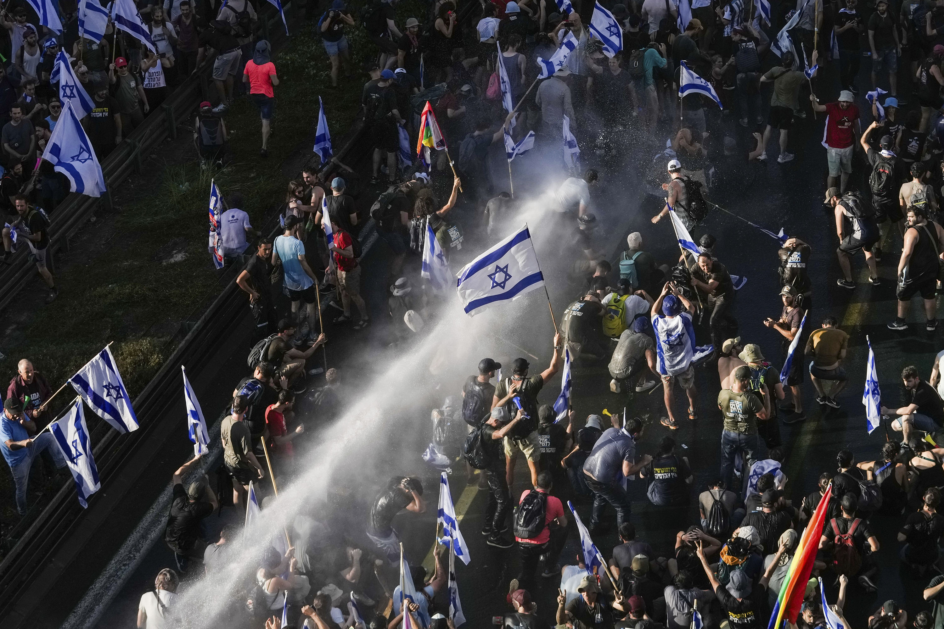 Israeli police use a water cannon to disperse demonstrators blocking a road during a protest against plans by Prime Minister Benjamin Netanyahu's government to overhaul the judicial system, in Jerusalem, Monday, July 24.