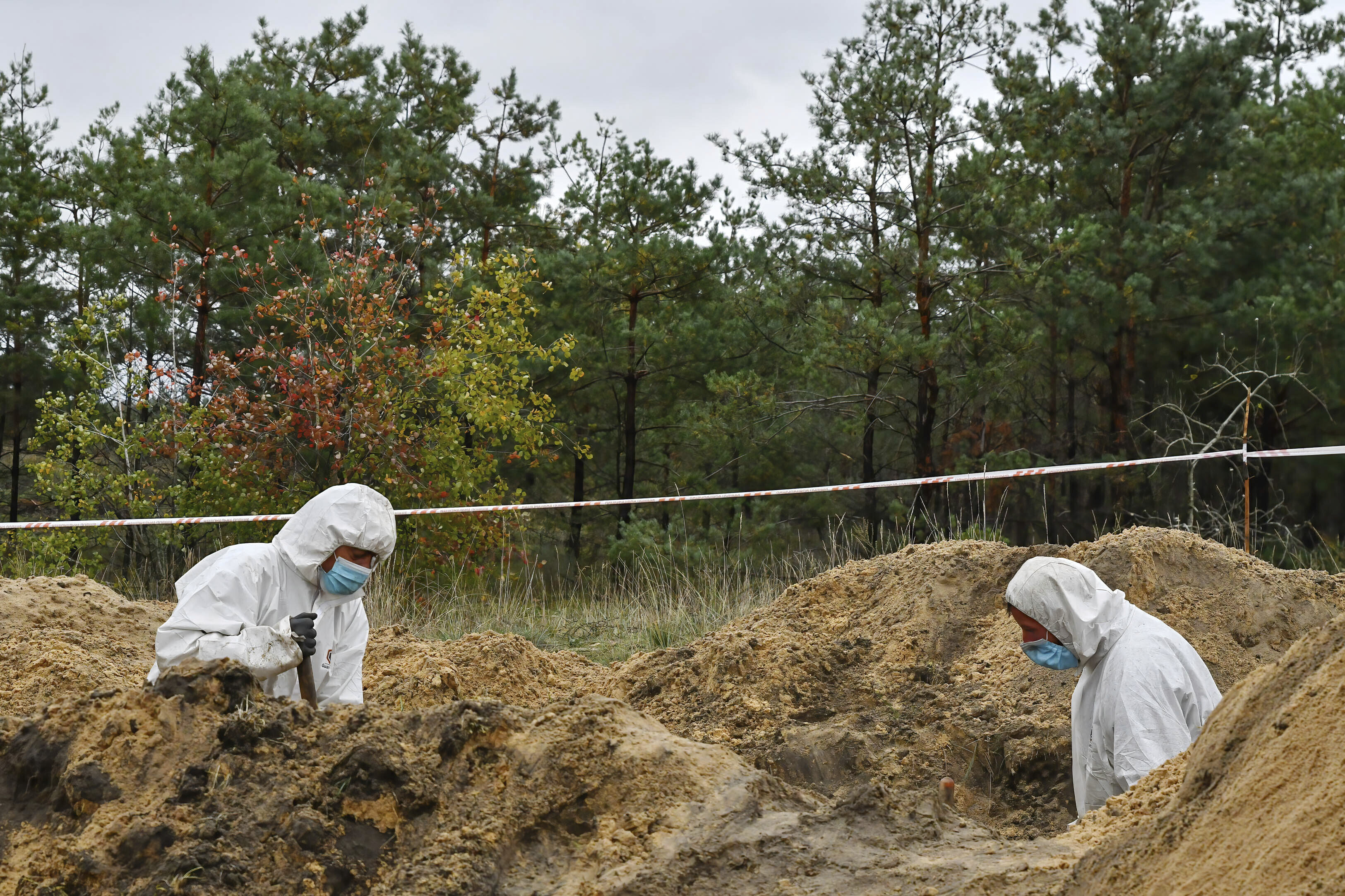 Members of a forensic team during an exhumation at a mass grave in Lyman, Ukraine, on Tuesday.