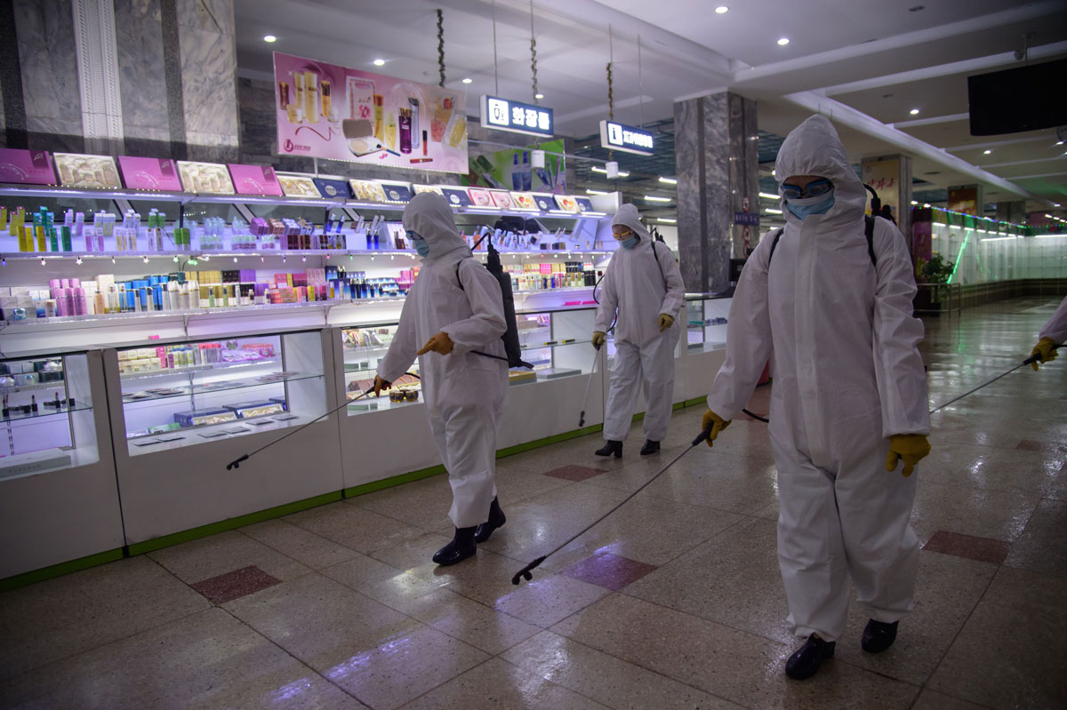 Health workers spray disinfectant inside the Pyongyang Department Store No. 1 prior to opening for business in Pyongyang, North Korea on December 28, 2020.