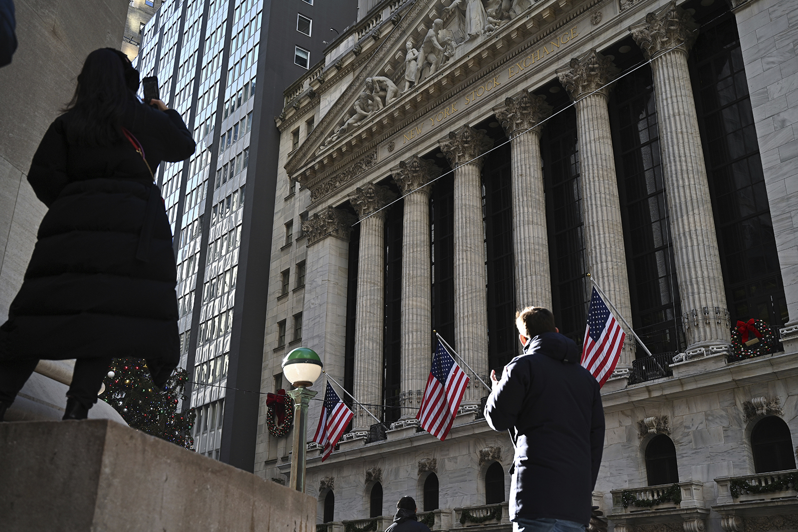 People walk past the New York Stock Exchange on January 2.