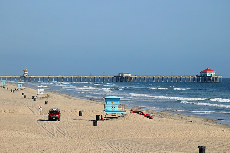  Lifeguards patrol an empty beach in front of the Huntington Beach Pier on May 3, in Huntington Beach, California. 