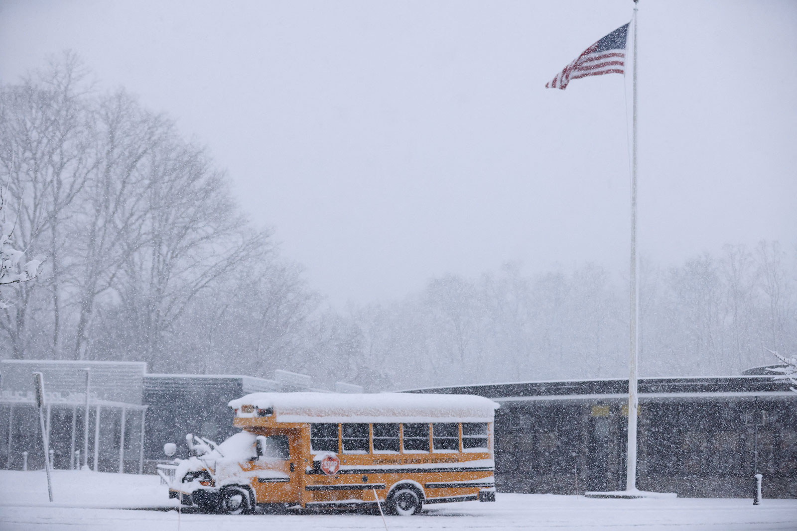 A school bus is covered in snow at the Northvale Public School in Northvale, New Jersey, on Tuesday. At least 5 inches of snow was reported in Bergen County, New Jersey.
