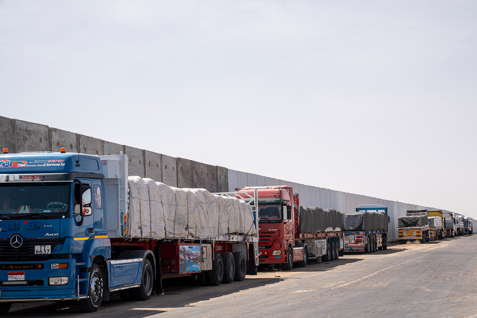 Aid trucks loaded with supplies for Gaza are waiting near the Egyptian-Palestinian border in preparation to enter Kerem Abu Salem crossing on May 26, in Rafah, Egypt.