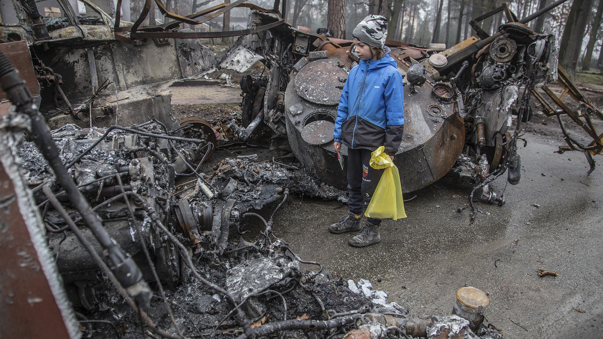 A boy looks at a destroyed Russian tank after recent battles in Bucha, Ukraine on Friday, Apr. 1.