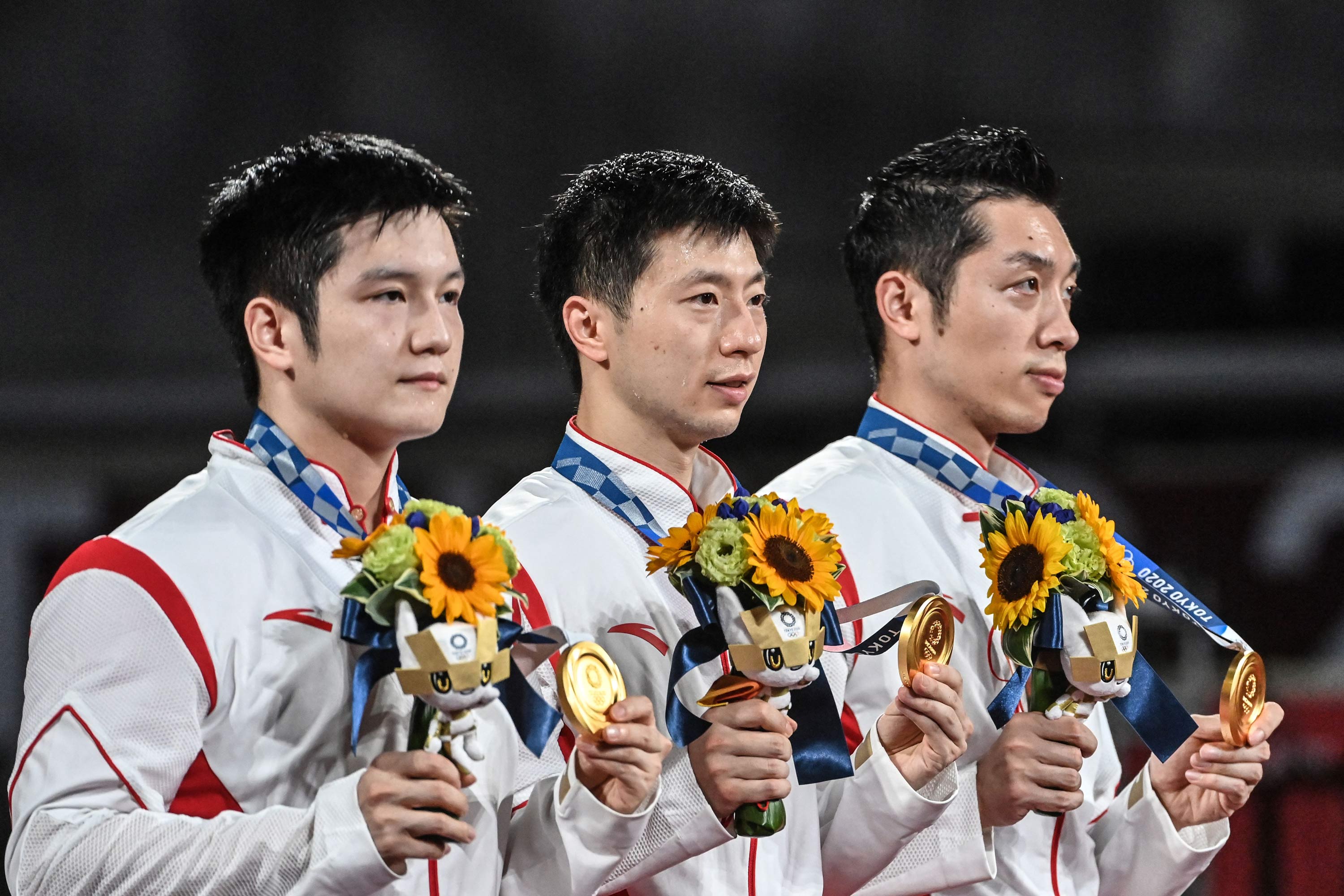From left, gold medallists China's Fan Zhendong, Ma Long and Xu Xin pose with their medals during the team table tennis medal ceremony on August 6.
