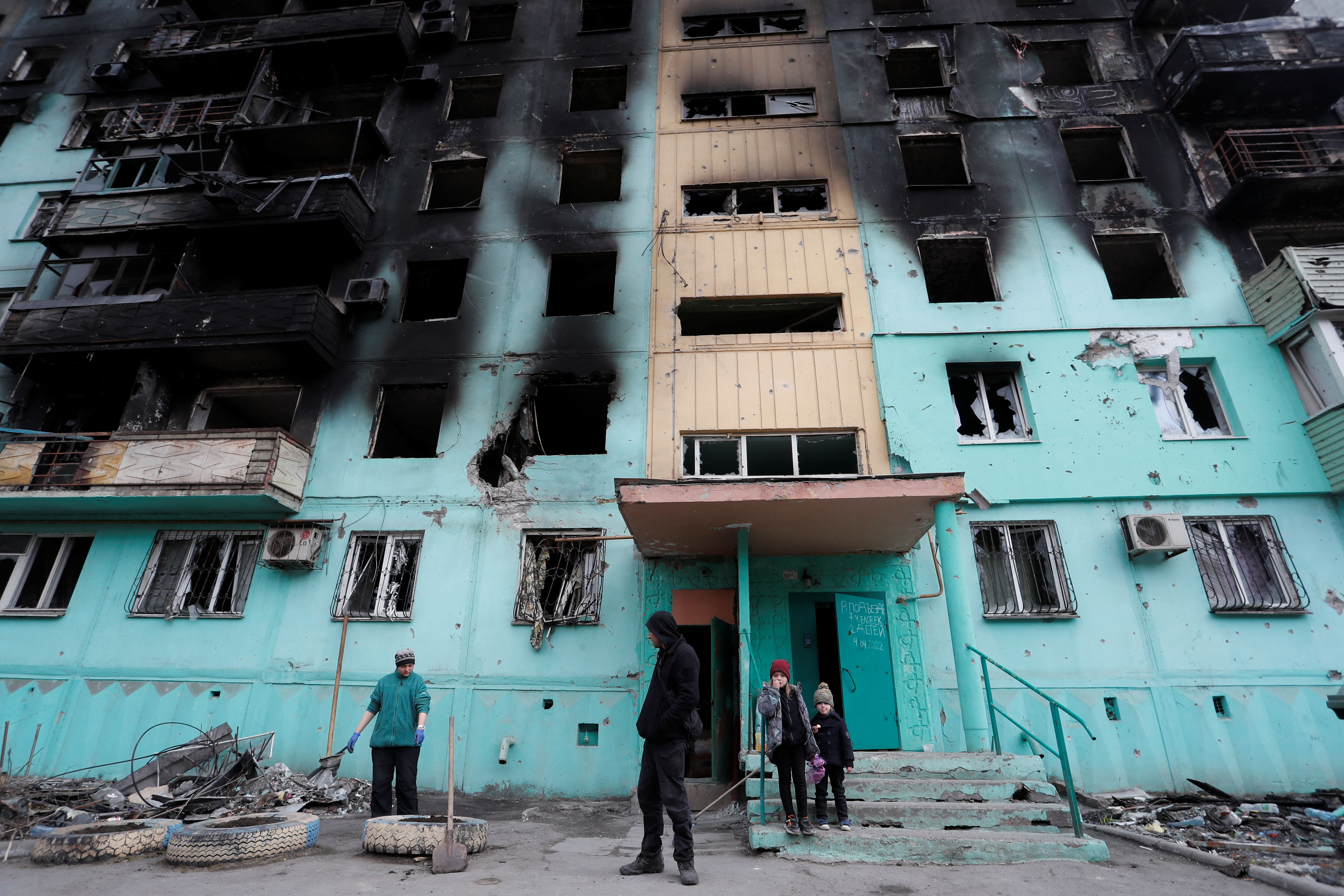 Local residents gather outside a damaged apartment building in the southern port city of Mariupol, Ukraine, on April 4.