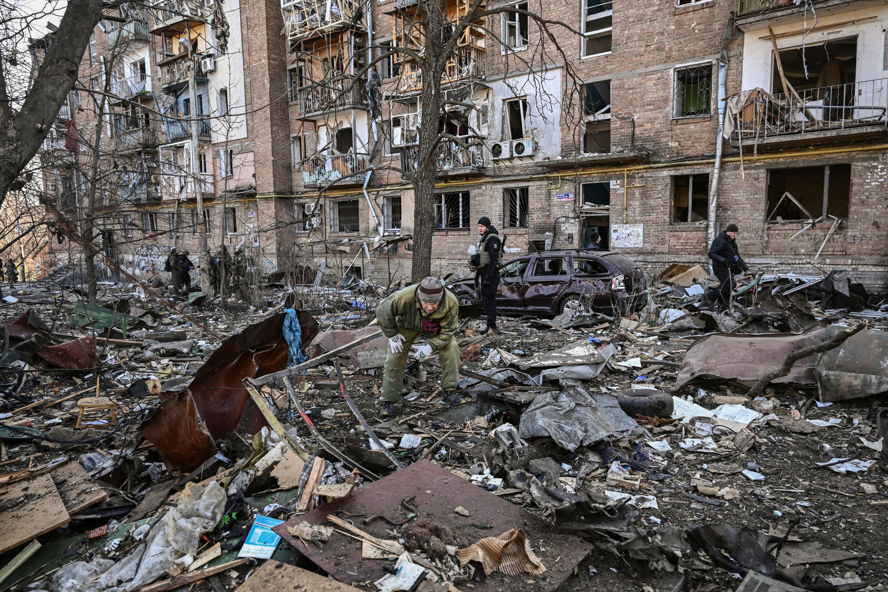 Các binh sĩ Ukraine đứng cạnh một tòa nhà bị hư hại tại khu dân cư sau trận pháo kích ở Kyiv, Ukraine, ngày 18/3.