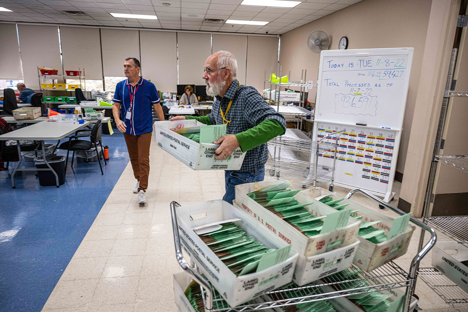 An election official carries a batch of ballots ready for tabulation at the Maricopa County Tabulation and Election Center in Phoenix on Tuesday. 