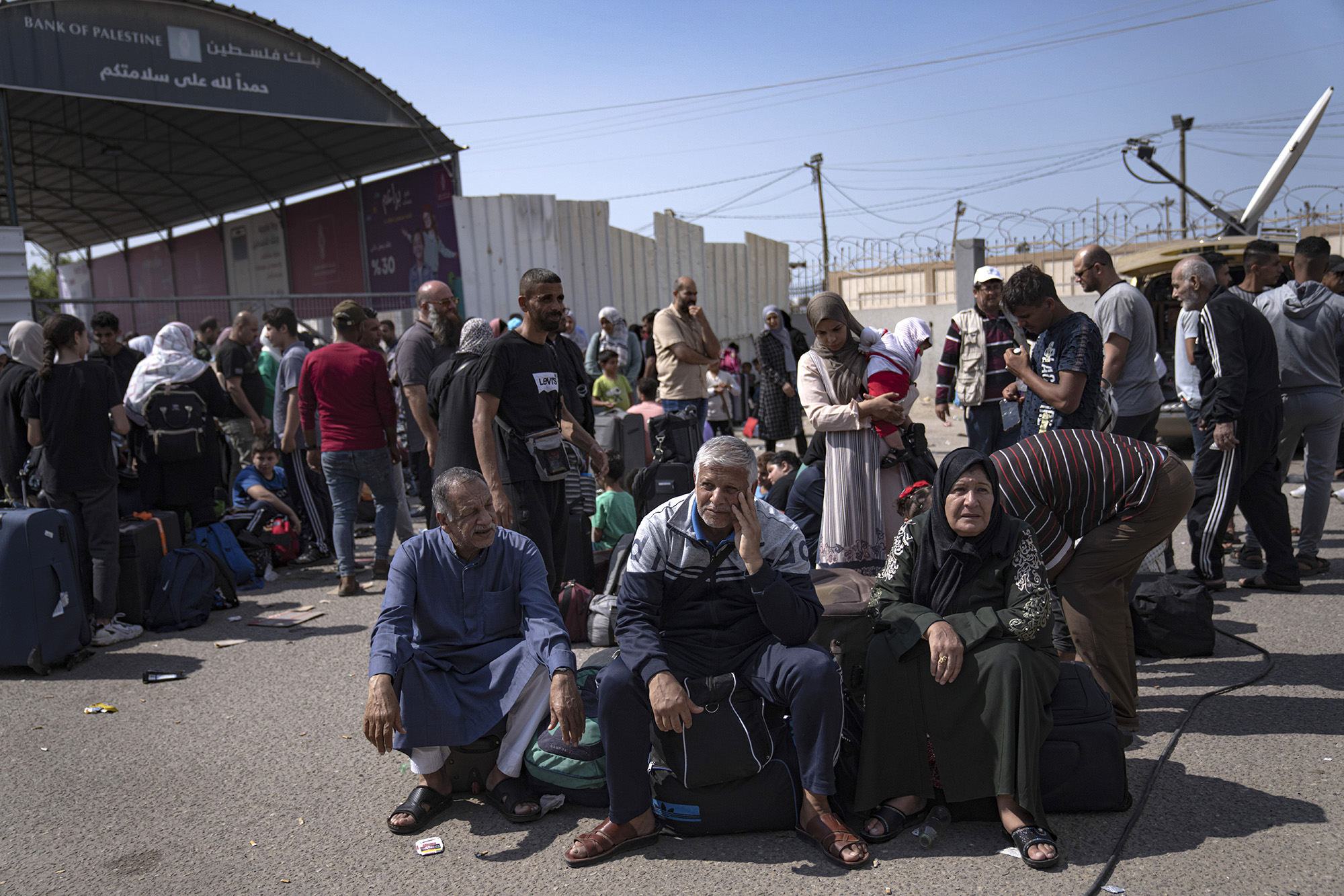 Palestinians wait to cross into Egypt at the Rafah border crossing in Gaza, on October 16.
