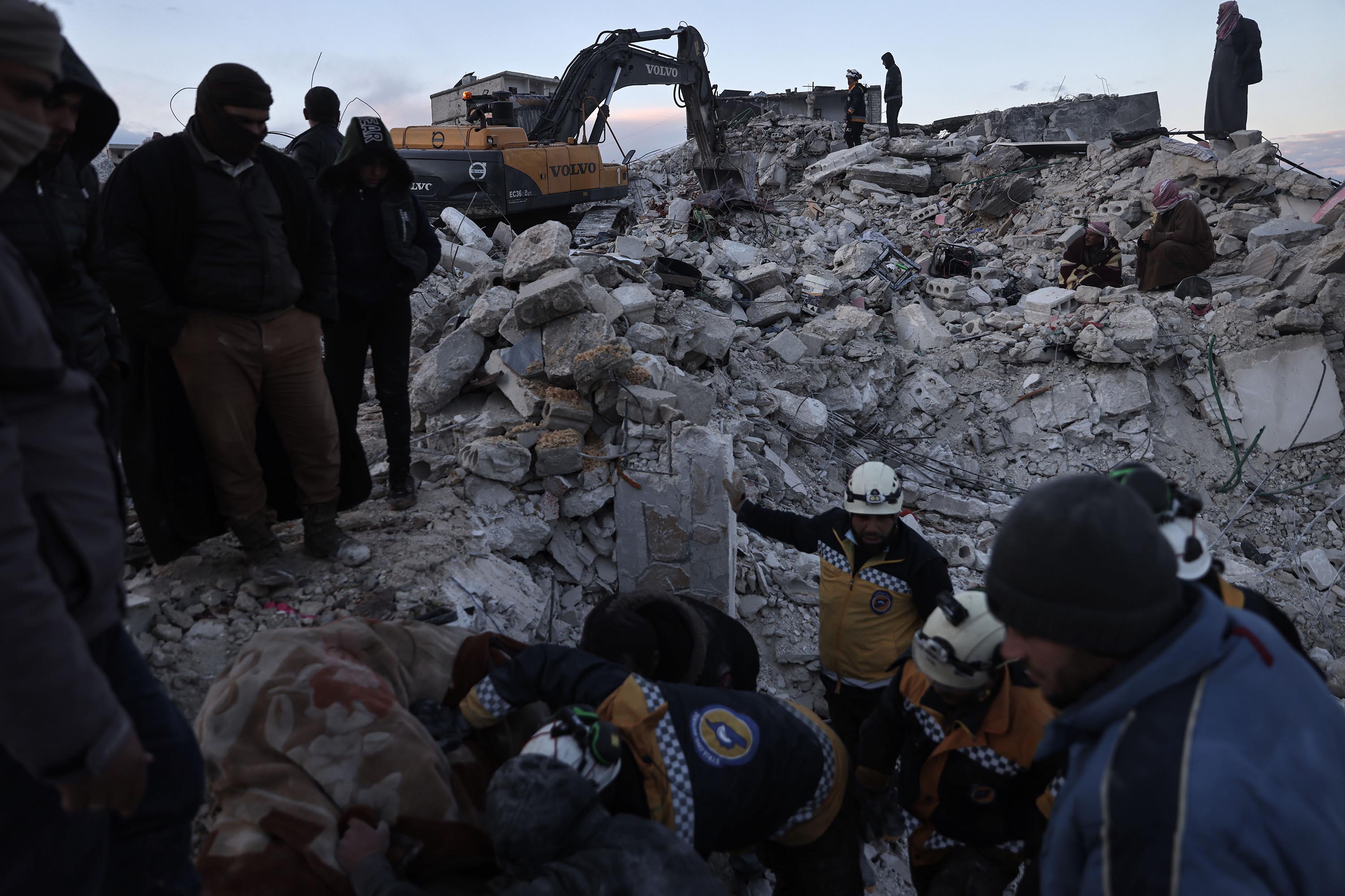 Civilians and members of the "White Helmets" work to save people trapped beneath a destroyed building in Harem, Syria, on Tuesday, February 7. 
